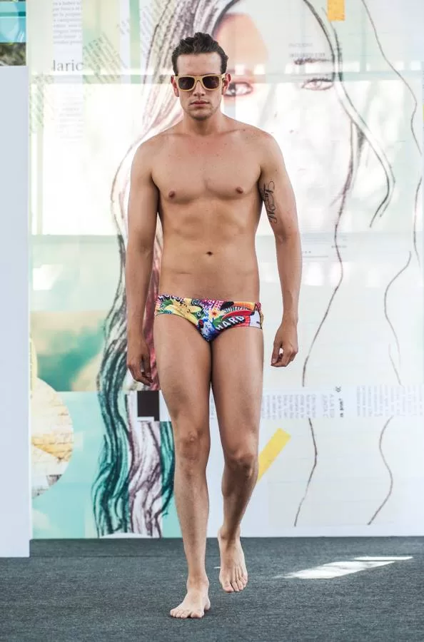 Modelo con tatuaje y traje de baño corto de colores de Lolos Swimwear camina descalzo en El Cubo, Colombiamoda 2013