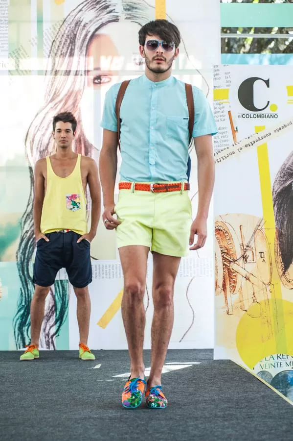 Modelo con camisa azul cielo, short verde neón y cinturón naranja de Lolos Swimwear en El Cubo, Colombiamoda 2013
