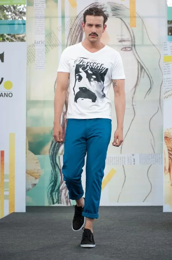 Modelo con bigote, camiseta blanca con retrato Forever Young de Latin Lover y pantalón azul en El Cubo