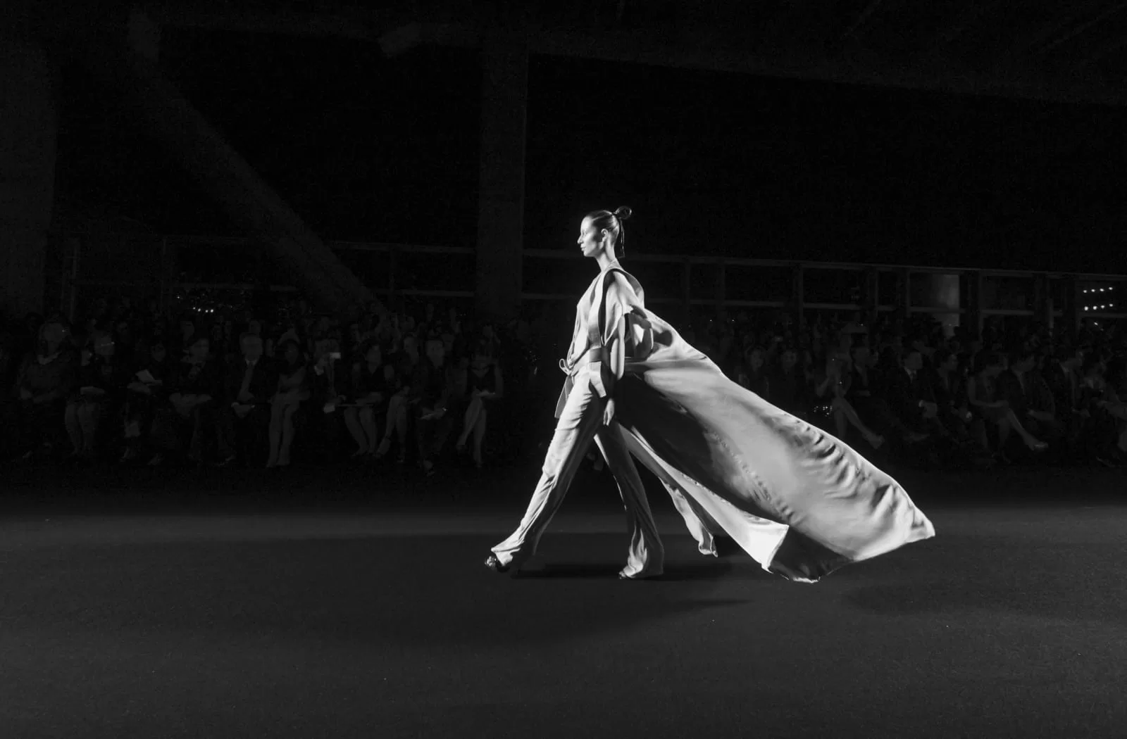 Modelo con abrigo largo y capa camina por la pasarela de Haider Ackermann ante el público de Colombiamoda 2013