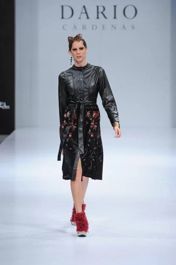 Modelo con abrigo de cuero negro bordado y zapatos de plumas rojas de Darío Cárdenas en Ixel Moda 2013
