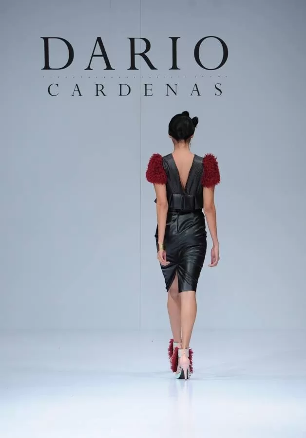 Modelo de espaldas con top de plumas rojas y falda de cuero de Darío Cárdenas en Ixel Moda 2013
