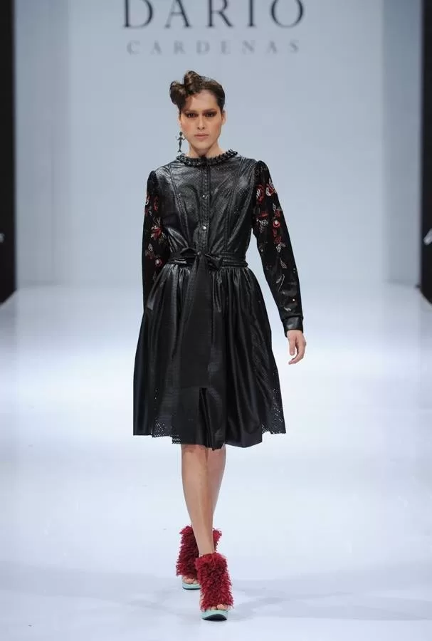 Modelo con vestido de cuero negro con mangas bordadas y zapatos de plumas rojas de Darío Cárdenas en Ixel Moda