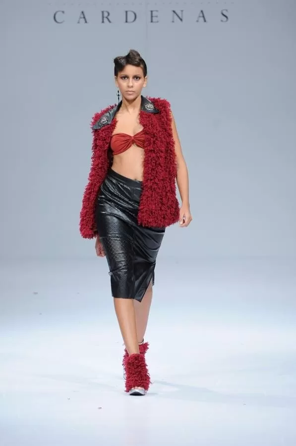 Modelo con chaleco de plumas rojas, top naranja y falda de cuero de Darío Cárdenas en Ixel Moda 2013
