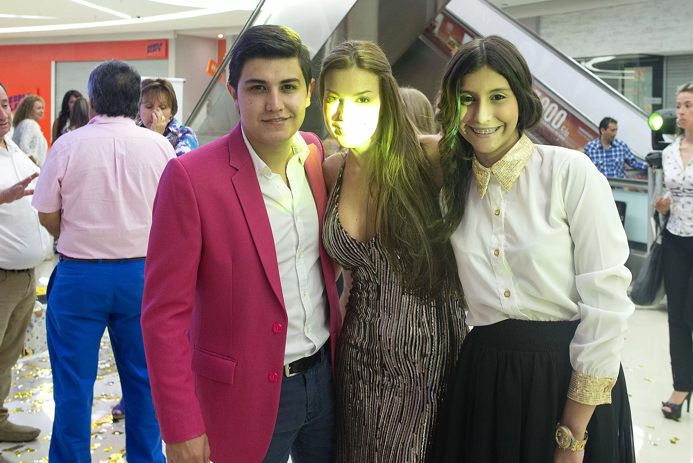 Invitado con blazer fucsia posa con Silvia Becerra y una invitada en la inauguración de la tienda