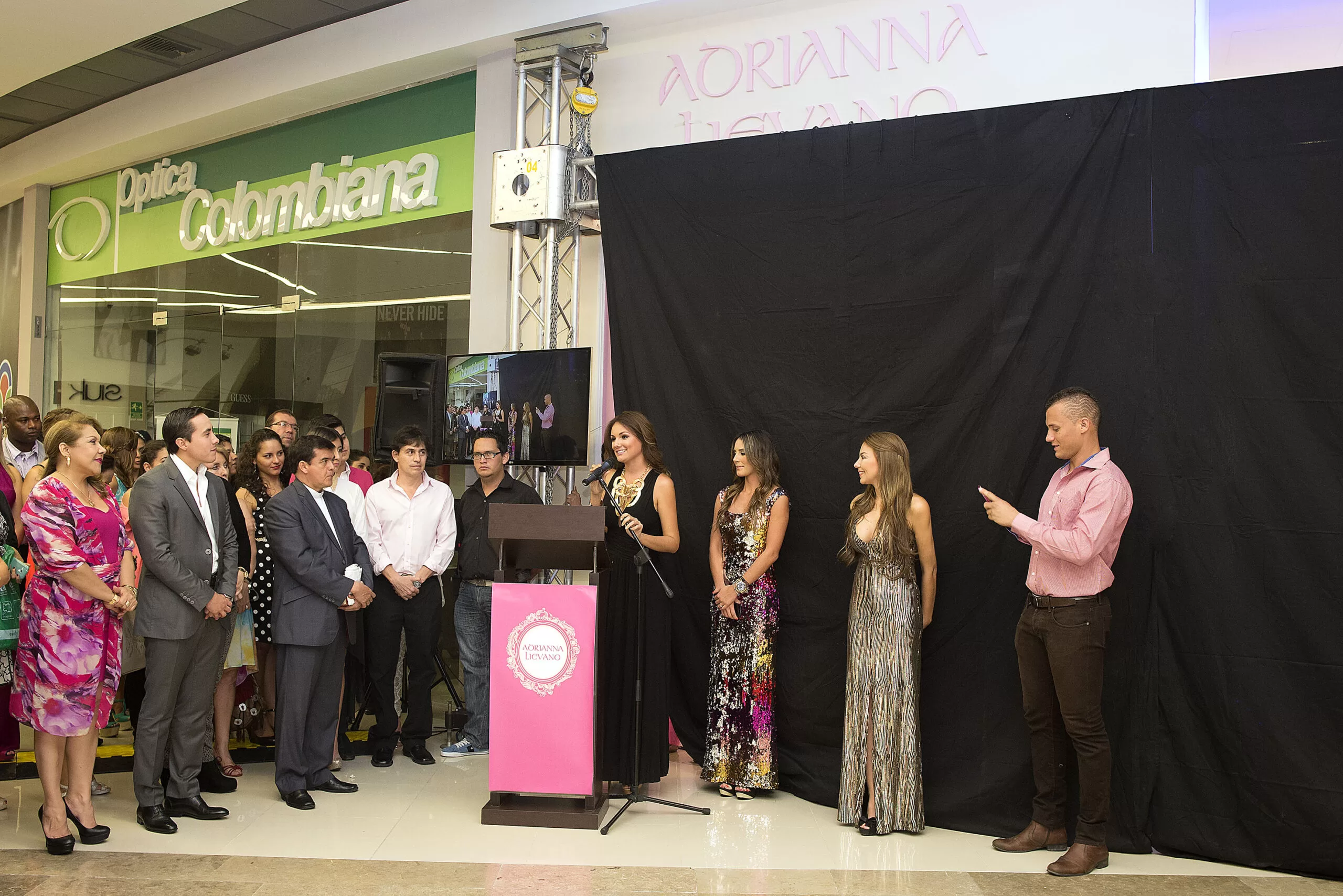 Silvia Becerra y Adriana Liévano con vestidos de lentejuelas frente al atril, inauguración de la tienda en Parque Caracolí