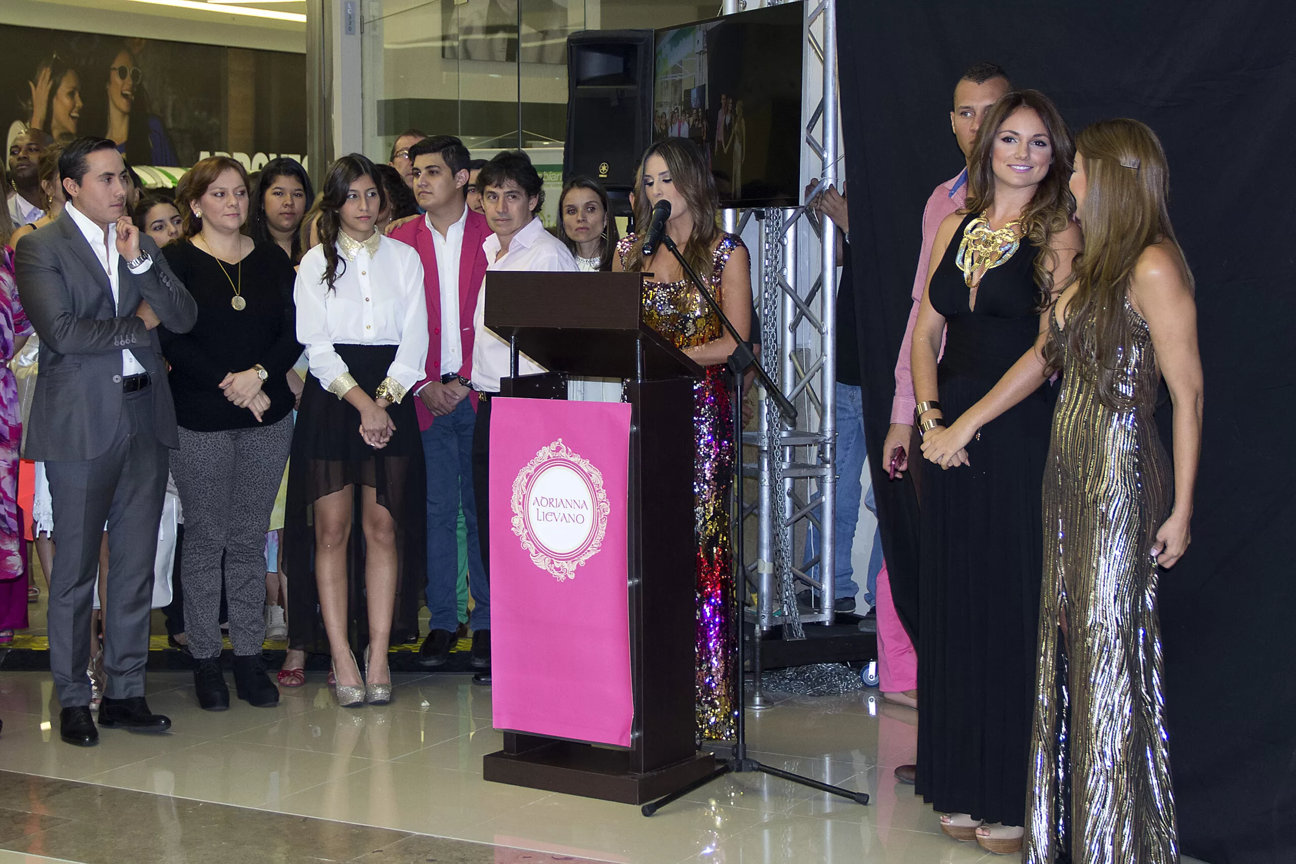 Silvia Becerra habla en el atril durante la inauguración de la tienda Adriana Liévano, con invitados alrededor