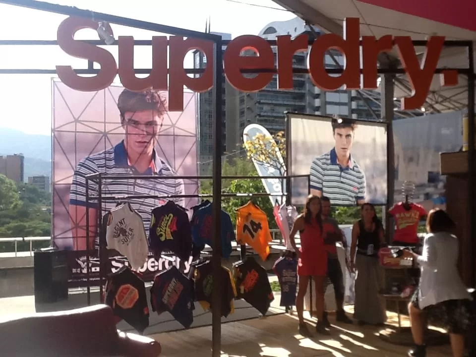 Stand de Superdry con camisetas colgadas y afiches de la marca en la feria comercial de Colombiamoda 2013
