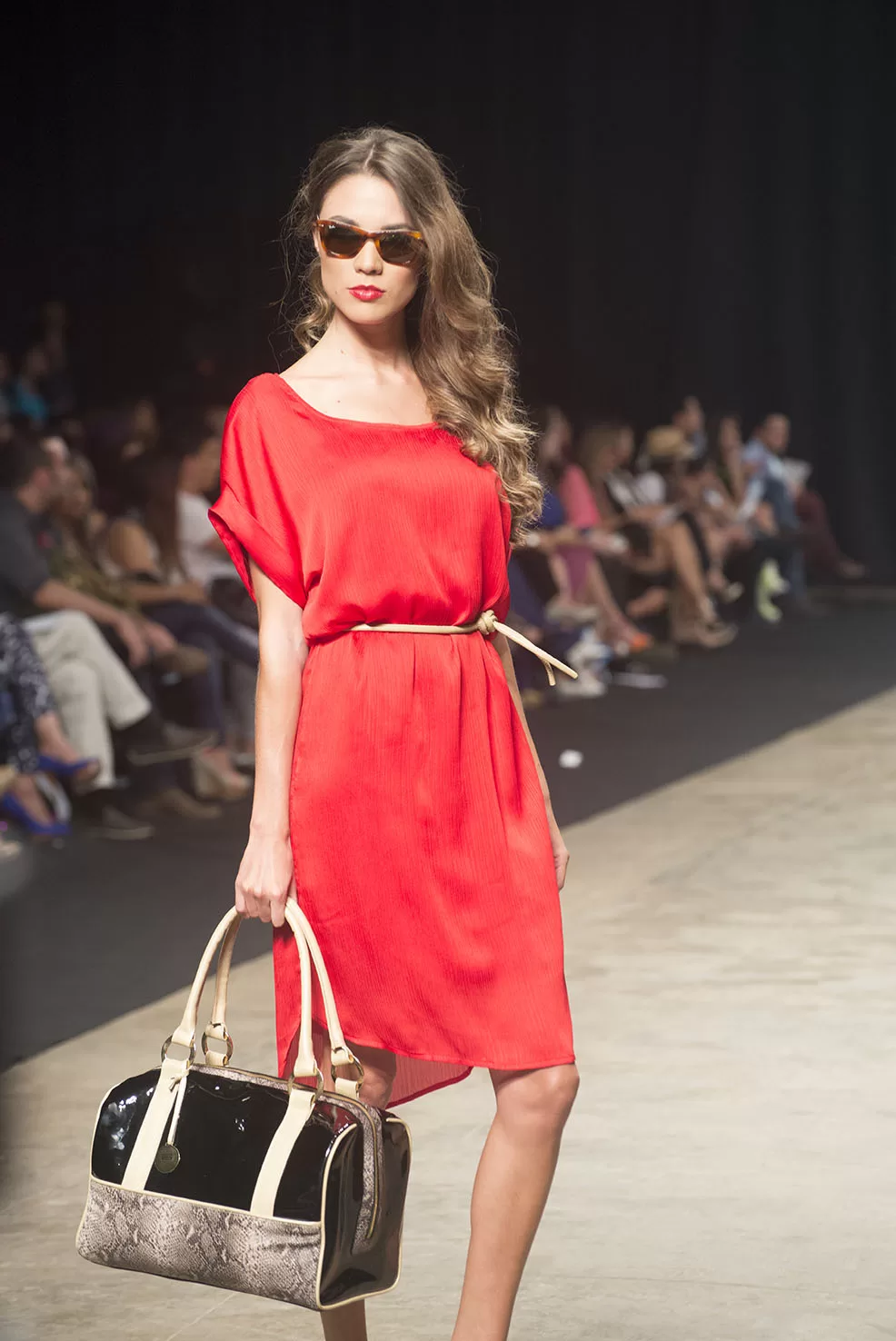Modelo con vestido rojo y bolso negro y beige de Carolina Ochoa en la pasarela del SFW 2013