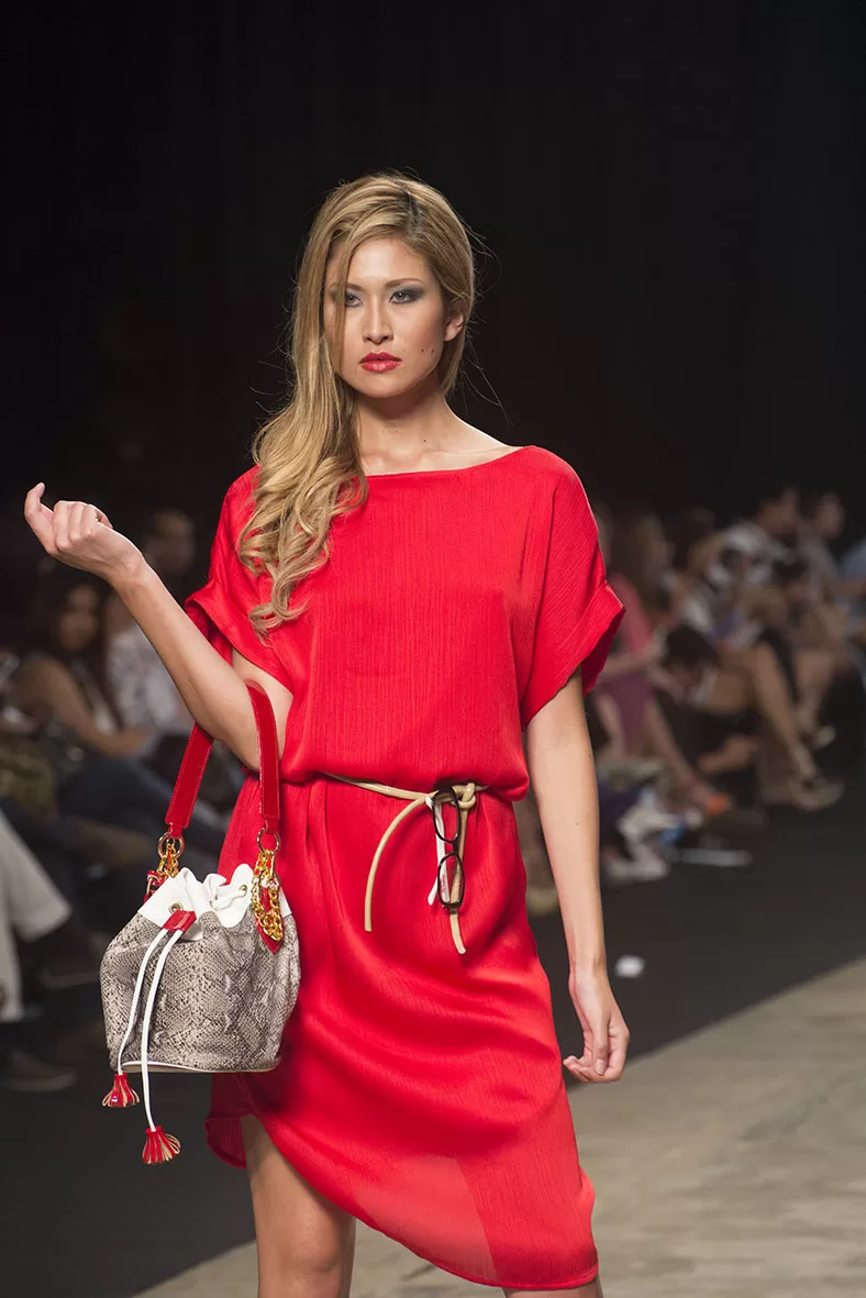 Modelo con vestido rojo y bolso pequeño de piel de serpiente de Carolina Ochoa en el SFW 2013