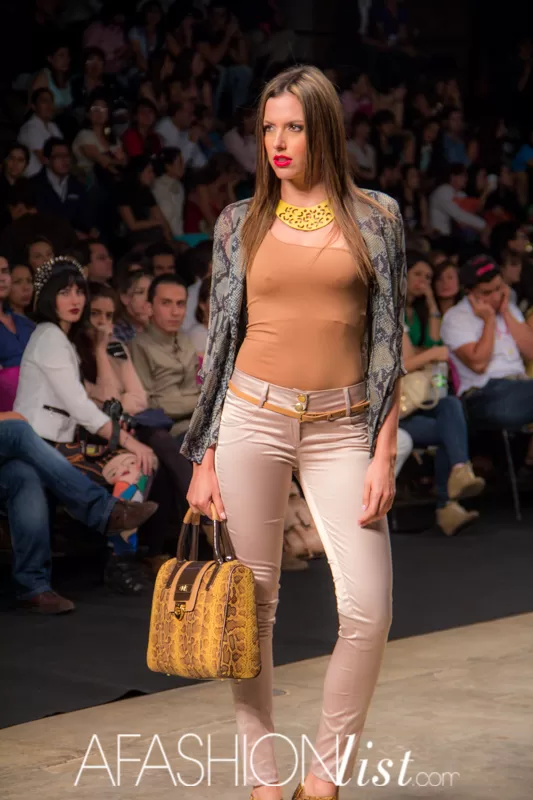Modelo con blazer de animal print, collar dorado, pantalón beige y bolso amarillo de SIUK en el SFW 2013