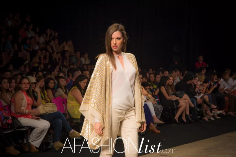 Modelo con capa dorada y pantalón blanco de Vásquez & García ante el público del SFW 2013