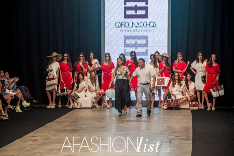 Modelos con vestidos rojos y blancos y bolsos de Carolina Ochoa al cierre de su pasarela en el SFW 2013