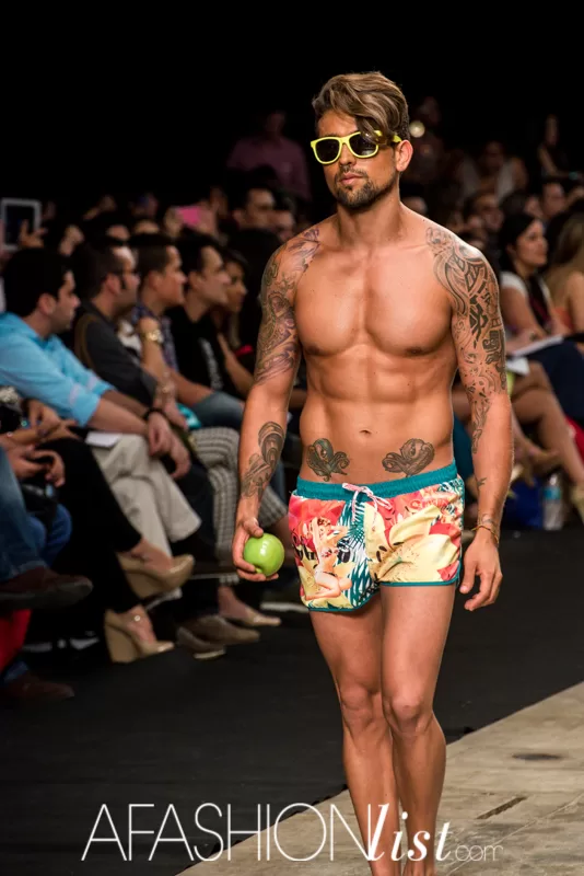 Modelo masculino con gafas amarillas y pantaloneta estampada de Lolos con una manzana verde en el SFW 2013