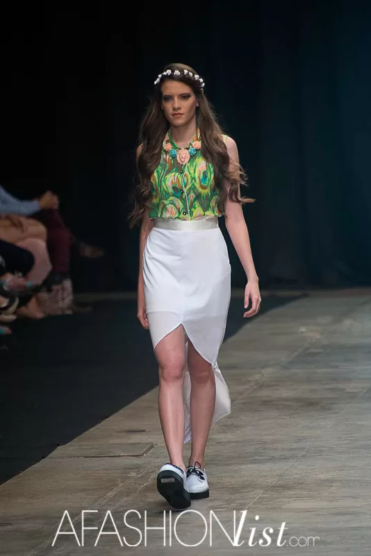 Modelo con corona de flores, top verde estampado y falda blanca asimétrica de Silvia Alfonzo en el SFW 2013