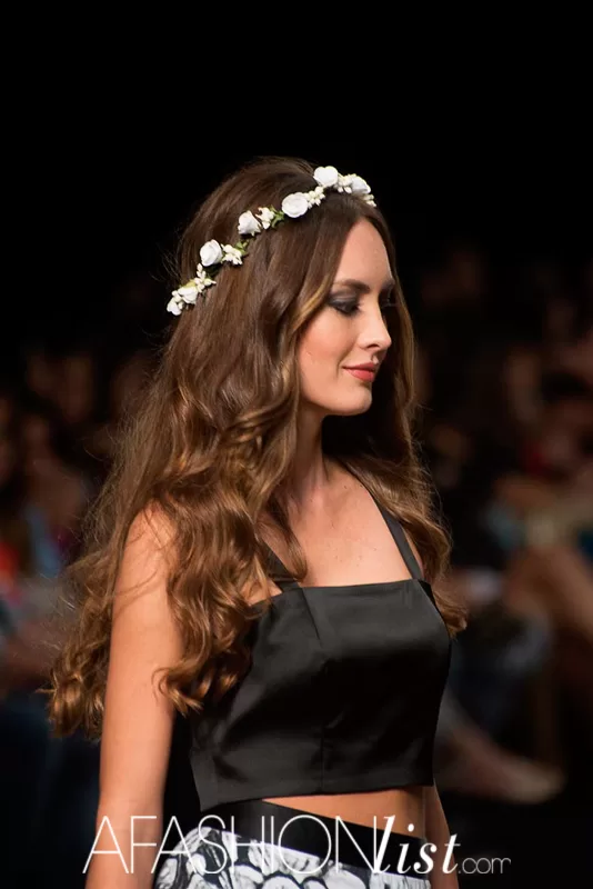 Perfil de una modelo con corona de flores blancas y top negro de Silvia Alfonzo en el SFW 2013