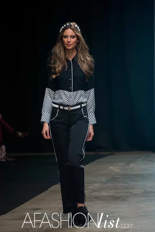 Modelo con corona de flores, blusa negra con lunares y pantalón negro de Silvia Alfonzo en el SFW 2013