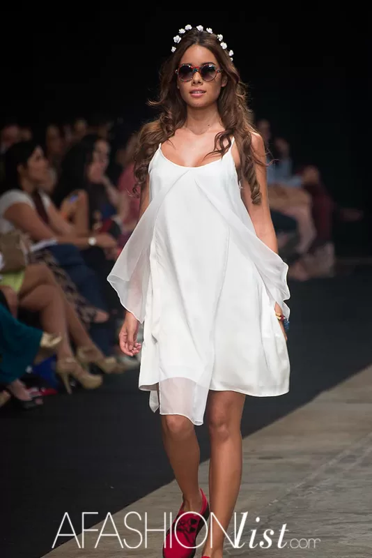 Modelo con corona de flores, gafas y vestido blanco vaporoso de Silvia Alfonzo en el SFW 2013