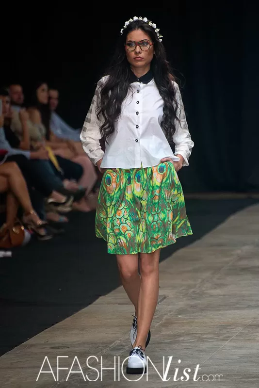 Modelo con corona de flores, gafas, camisa blanca y falda verde estampada de Silvia Alfonzo en el SFW 2013