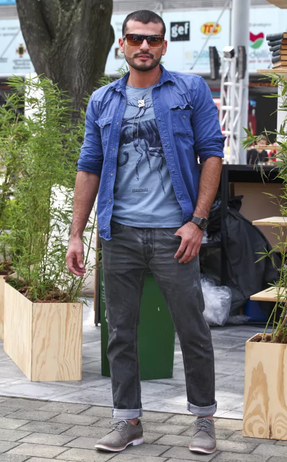 Hombre con camisa de jean y jeans grises entre las plantas de la Zona Urbana de Colombiatex 2014