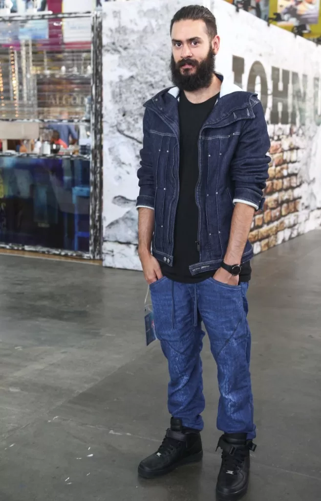 Hombre con barba, chaqueta de jean, camiseta negra y jeans azules en el Denim Day de Colombiatex 2014