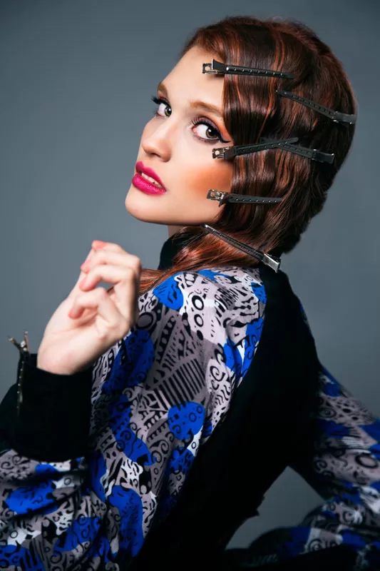 Editorial: modelo pelirroja con pinzas en el cabello y blusa estampada azul, de espaldas