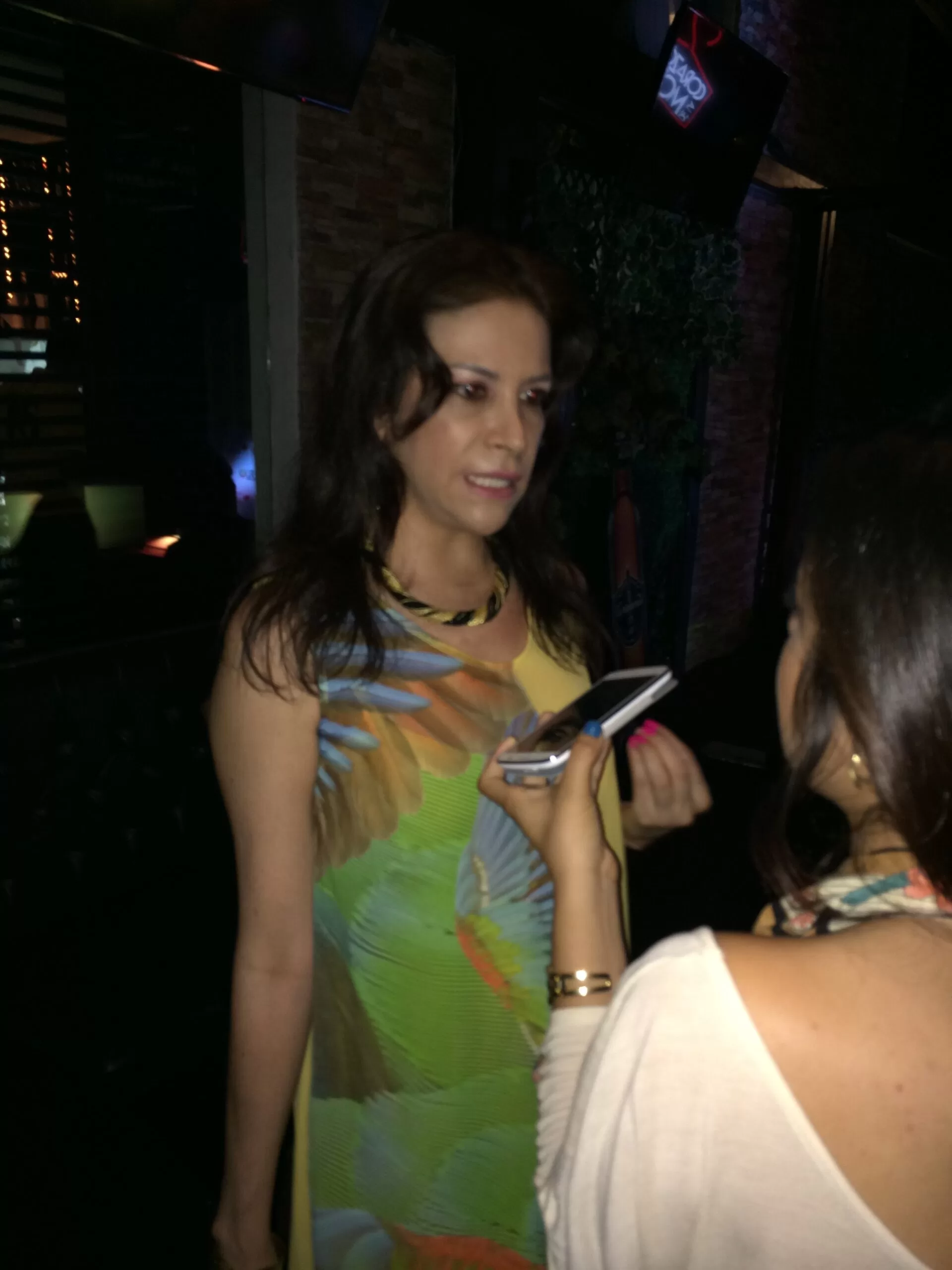 Diseñadora con vestido estampado tropical es entrevistada en el lanzamiento de Corazón de la Moda