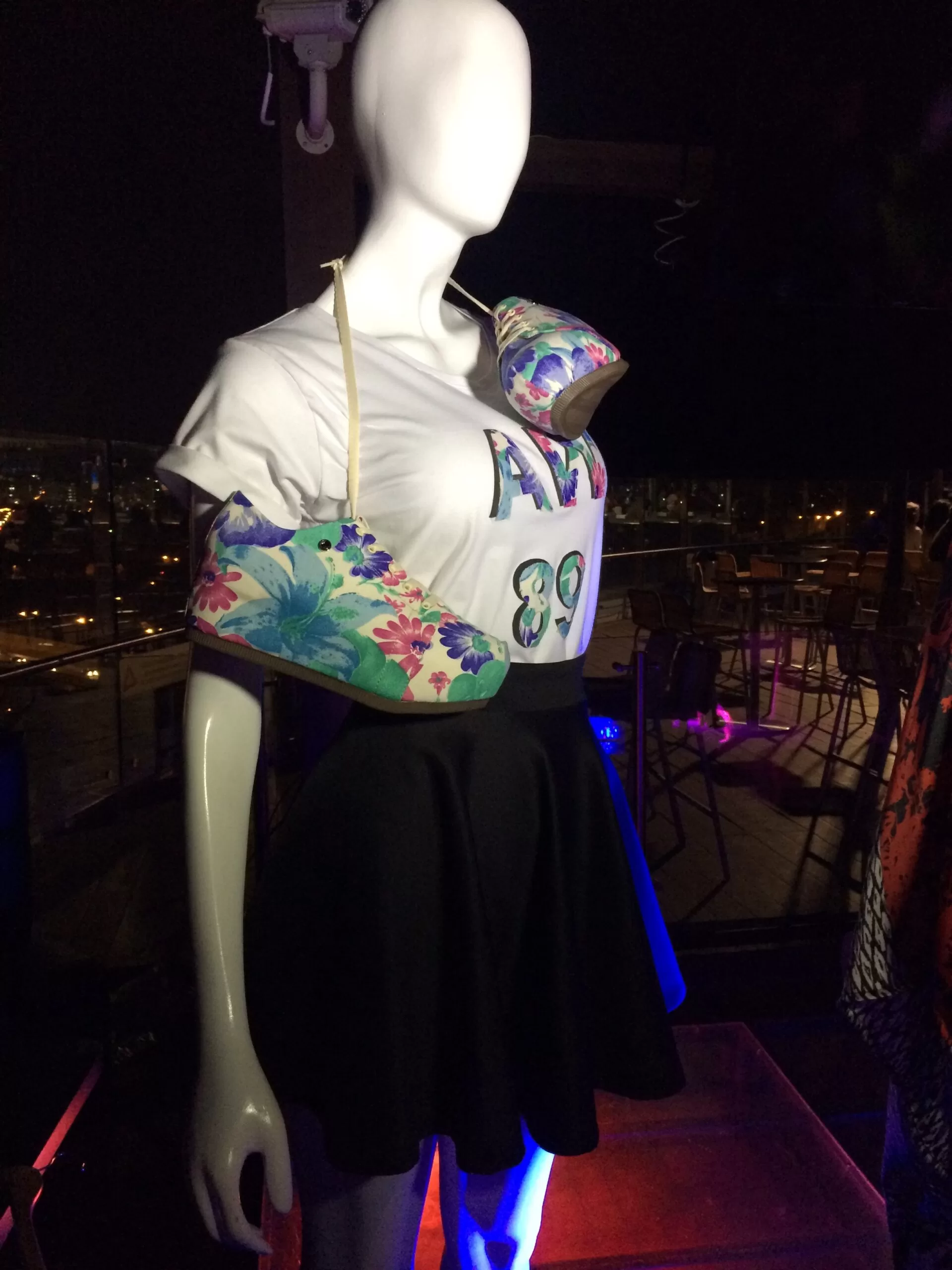 Maniquí con top blanco, falda negra y bolso estampado de un diseñador santandereano