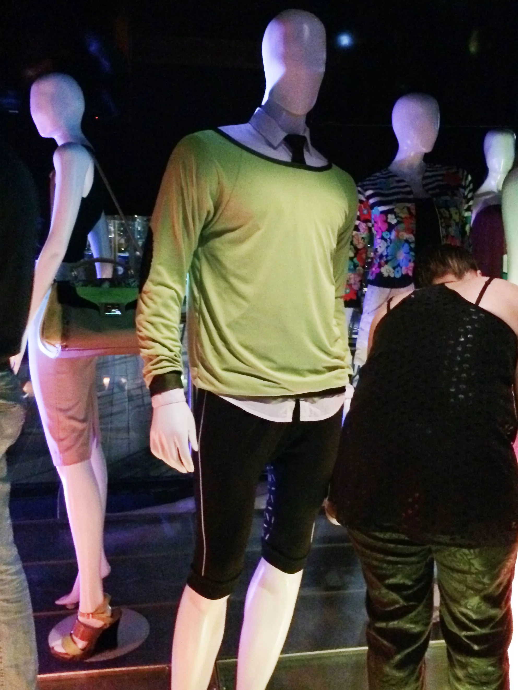 Maniquí con camiseta verde y short negro entre otros maniquíes en el lanzamiento