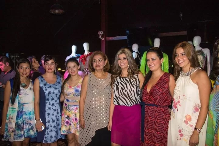 Grupo de diseñadoras con vestidos estampados posa en la Birrería de Cacique durante el lanzamiento