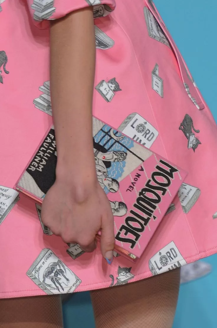 Clutch con forma de libro Mosquitoes con falda rosa en pasarela